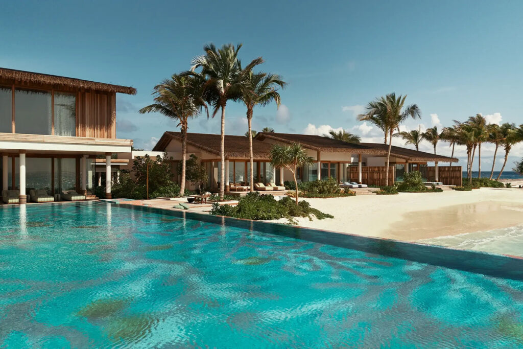 Turquoise pool beside the residences and white sand on Nowhere Private Island