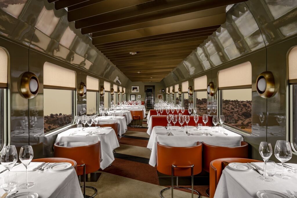 La Dolce Vita Orient Express restaurant car with orange dining chairs and white tablecloths