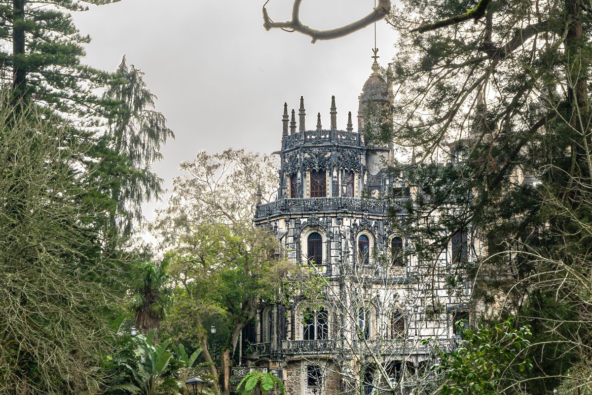 Elaborate palace stonework framed by trees at Quinta da Regaleira in Sintra