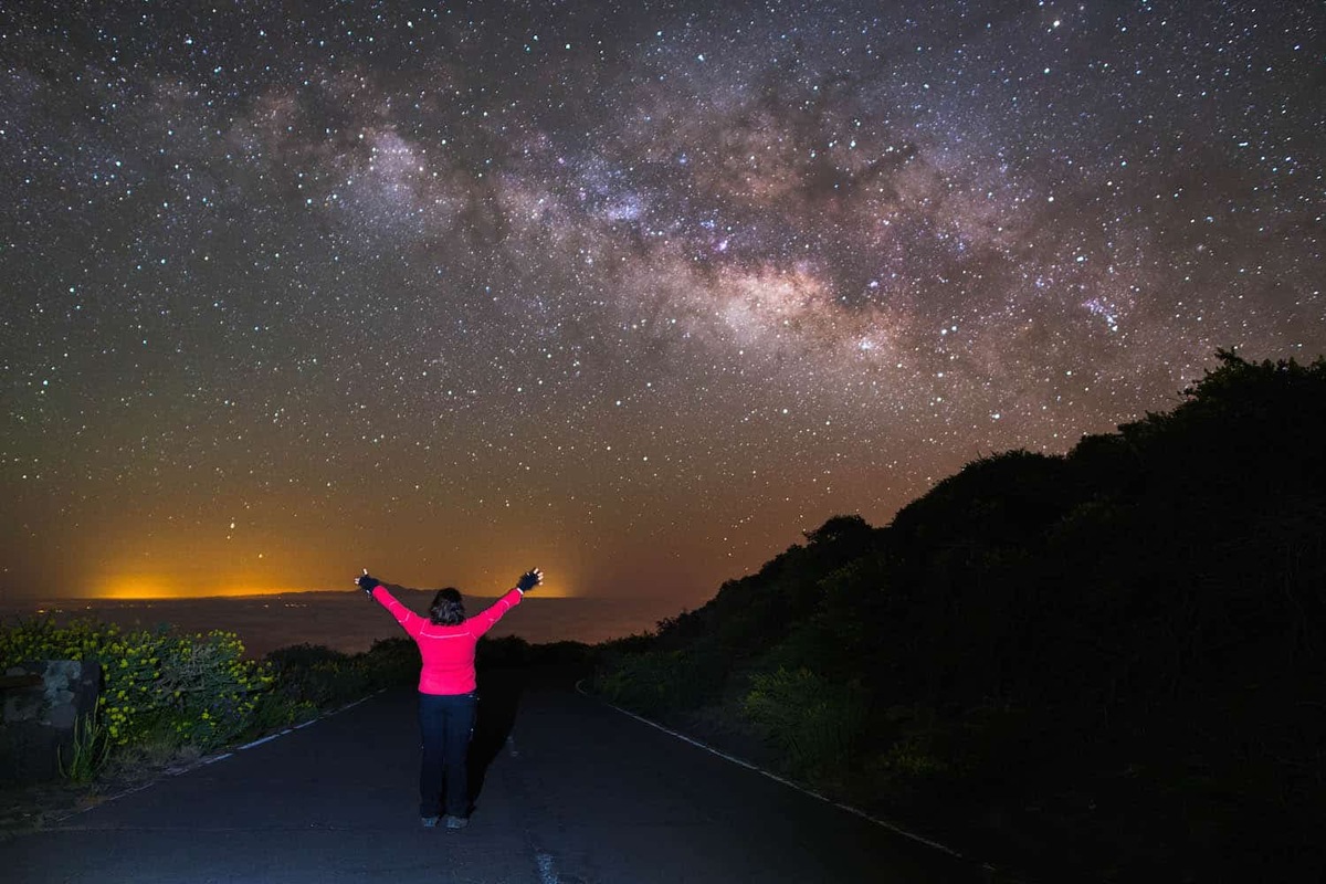 A visitor stands beneath the Milky Way near Roque de los Muchachos on La Palma