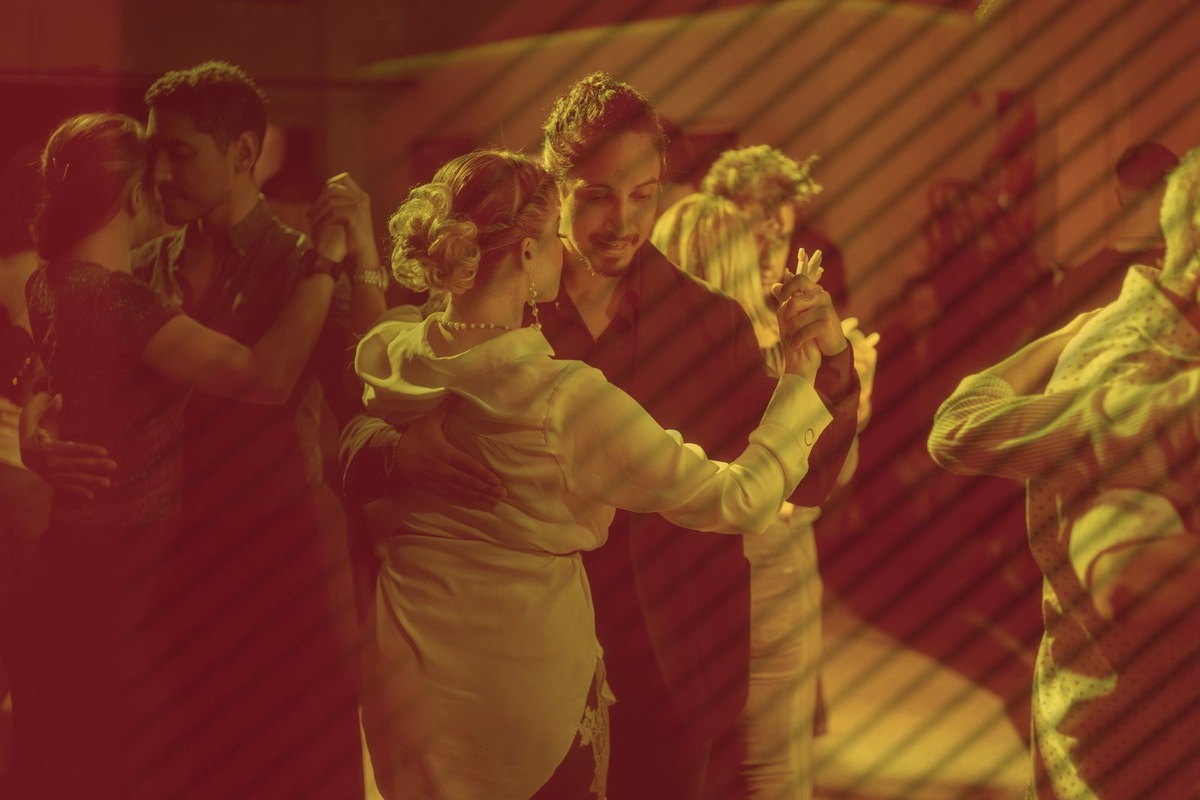 Dancers practice together in warm light at Avenida Tango in Buenos Aires