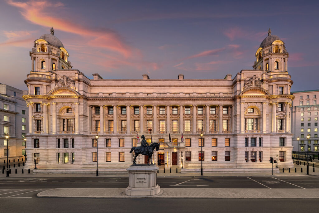 Raffles London at The OWO illuminated beneath a pink evening sky on Whitehall